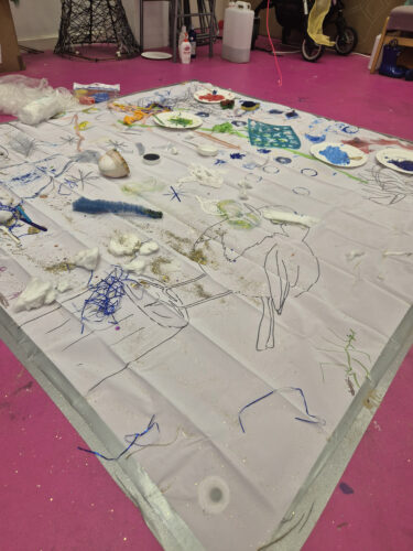 a big art play piece being done by children